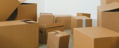 Cardboard boxes on floor in house during relocation - how to pack kitchen for moving